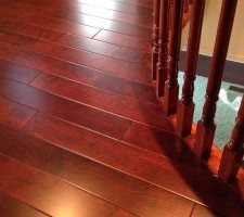 Polished cherry hardwood flooring showing meticulous transition details on a residential landing